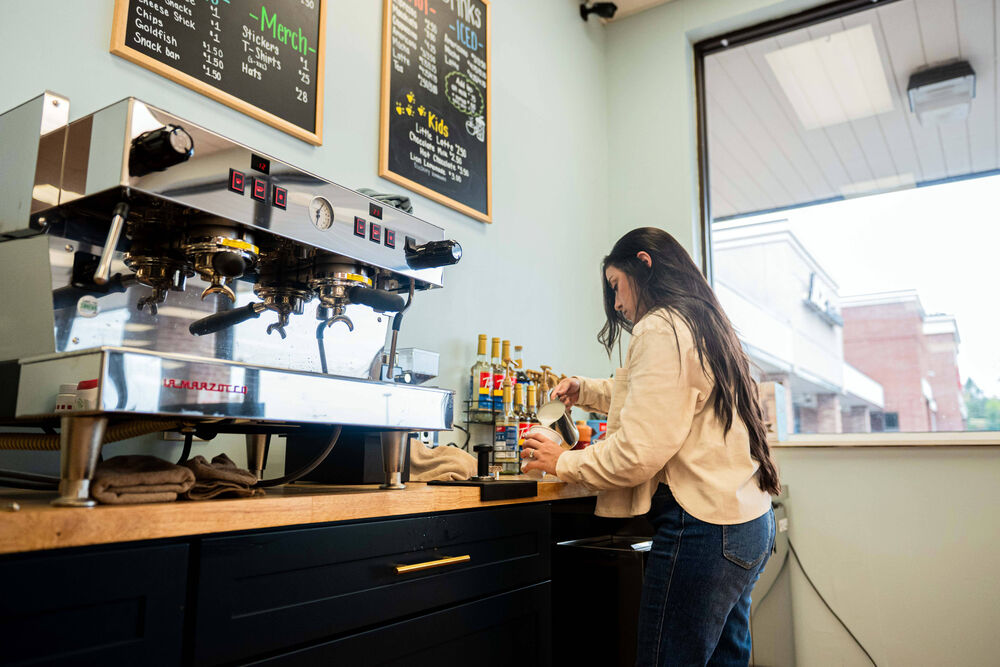 A barista making drinks at the Little Lions espresso bar