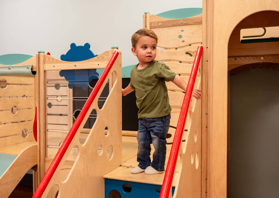 A child climbing the wooden play structure